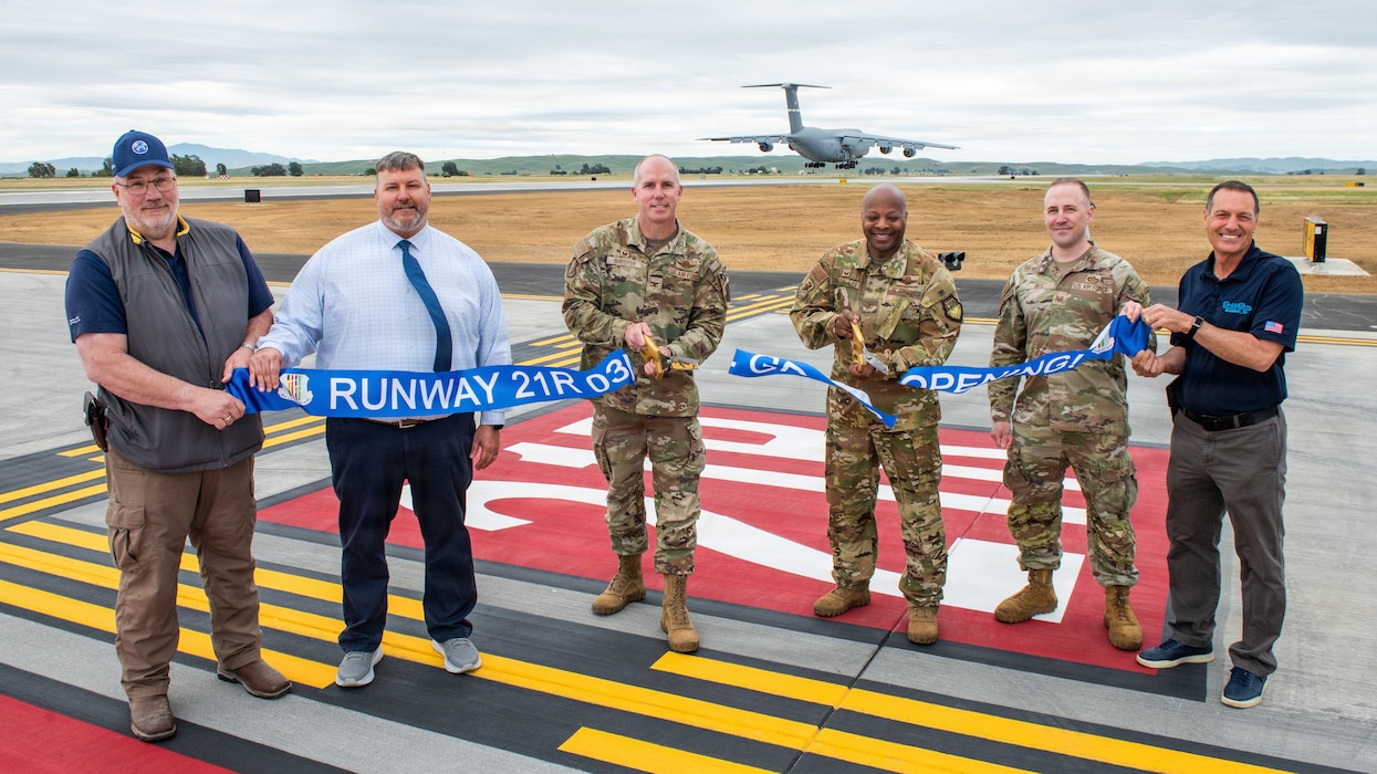 Wing leadership and project contractor cut ribbon as C-5 prepares for landing on new runway.