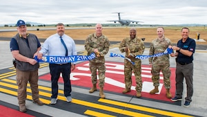 Wing leadership and project contractor cut ribbon as C-5 prepares for landing on new runway.