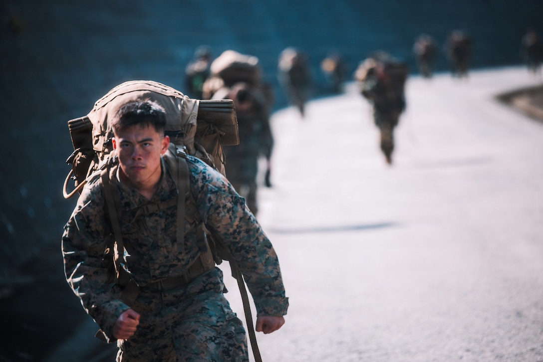 U.S. Marine Corps Sgt. Lucas Lu, a native of Indiana and a combat graphics specialist with Headquarters Battalion, 3rd Marine Division, conducts a hike during a communication strategy and operations field training exercise at Camp Hansen, Okinawa, Japan, April 8, 2026.