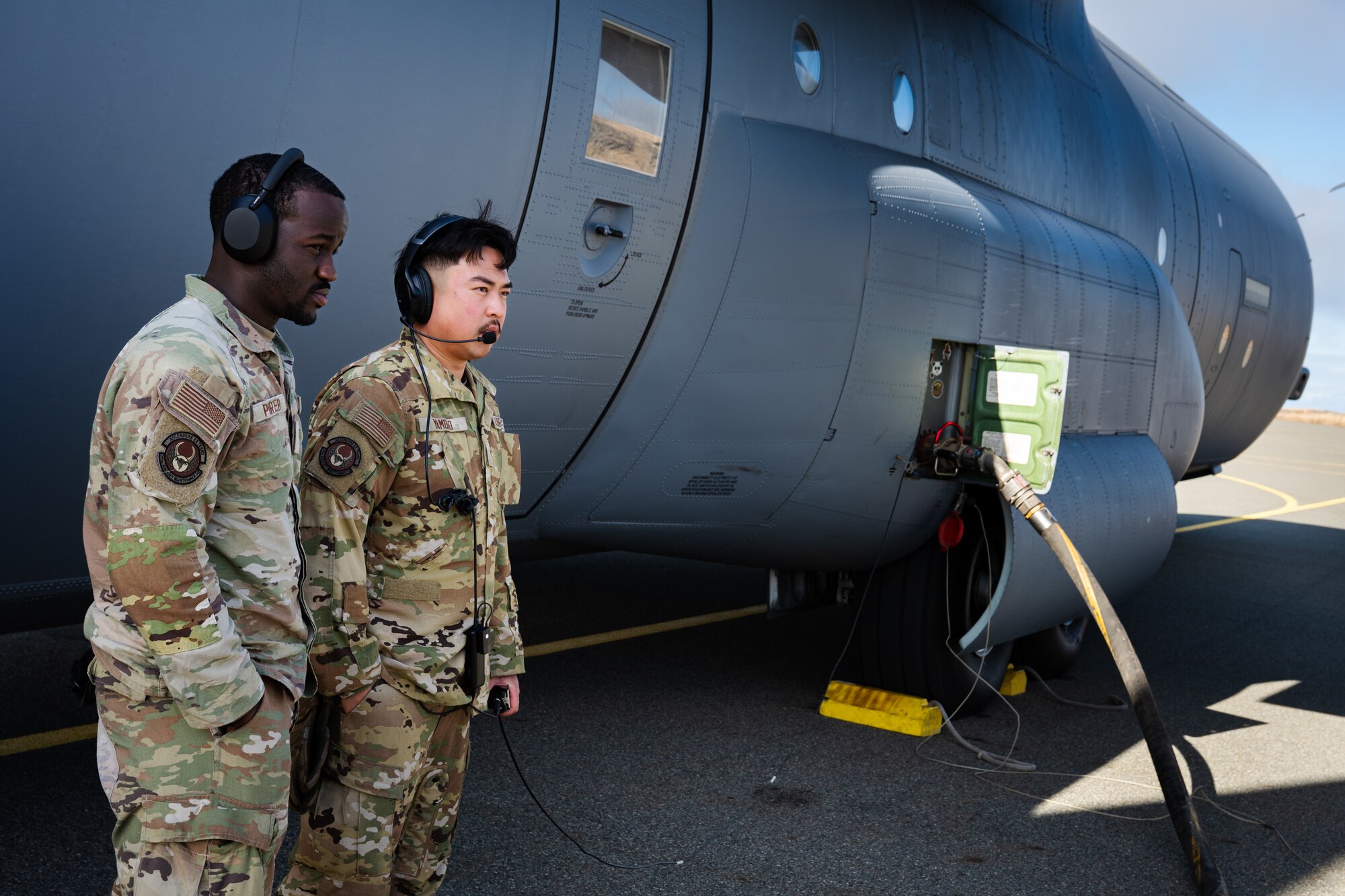 U.S. Air Force Senior Airman Jamaray Porter, 317th Aircraft Maintenance Squadron crew chief, left, and Senior Airman Christian Yambao, 317th AMXS assistant flying crew chief, monitor refueling operations for a Maximum Endurance Operation en route to Exercise Balikatan 2026 at Eareckson Air Station, Alaska, April 16, 2026. Balikatan is a longstanding annual exercise between the Armed Forces of the Philippines and U.S. military designed to strengthen our ironclad alliance, improve our capable combined force, and demonstrate our commitment to regional security and stability. (U.S. Air Force photo by Senior Airman Jade M. Caldwell)