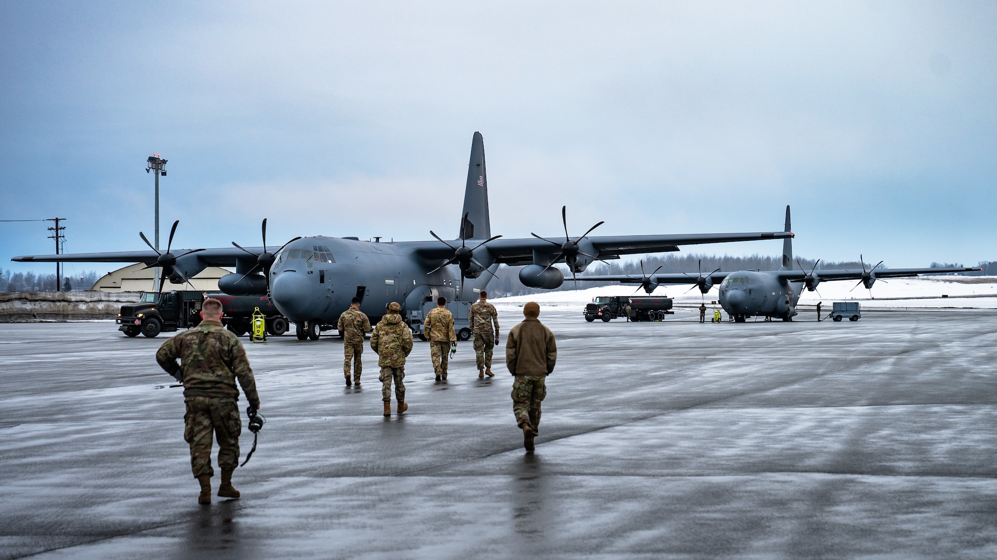 U.S. Airmen assigned to the 317th Airlift Wing and 7th Bomb Wing transit to a C-130J Super Hercules aircraft equipped with external fuel tanks before continuing with a Maximum Endurance Operation en route to Exercise Balikatan 2026 at Joint Base Elmendorf-Richardson, Alaska, April 16, 2026. Balikatan is a longstanding annual exercise between the Armed Forces of the Philippines and U.S. military designed to strengthen our ironclad alliance, improve our capable combined force, and demonstrate our commitment to regional security and stability. (U.S. Air Force photo by Senior Airman Jade M. Caldwell)