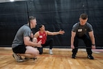 Gaby Serrati, CrossFit seminar trainer, instructs U.S. Space Force Guardians on proper deadlift form during a Space Force CrossFit training seminar at the Rambler Fitness Center, Joint Base San Antonio-Randolph, April 3, 2026. Guardians rehearsed each lift multiple times to build muscle memory and confidence. (U.S. Air Force photo by Senior Airman Gabriel Jones)