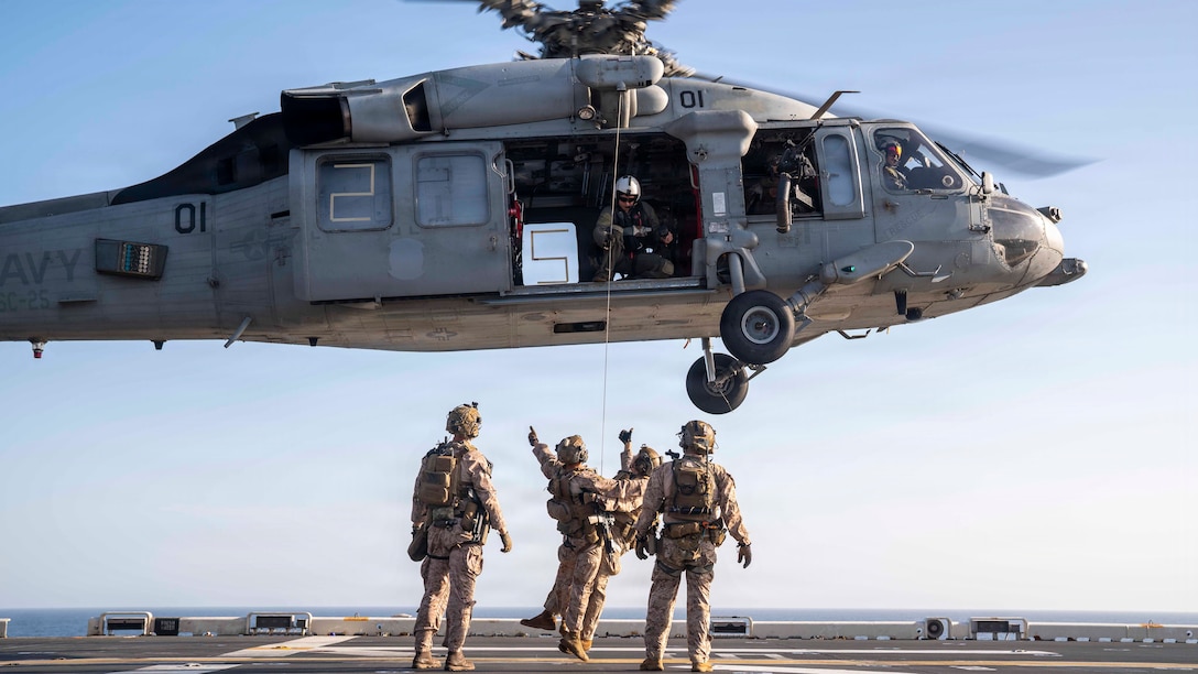 U.S. Sailors and Marines conduct live-hoist training with an MH-60S Sea Hawk helicopter, attached to Helicopter Sea Combat Squadron (HSC) 25, on the flight deck of America-class amphibious assault ship USS Tripoli (LHA 7), April 15, 2026. Tripoli is deployed to the U.S. 5th Fleet area of operations to support maritime security and stability in the Middle East. (U.S. Navy photo)