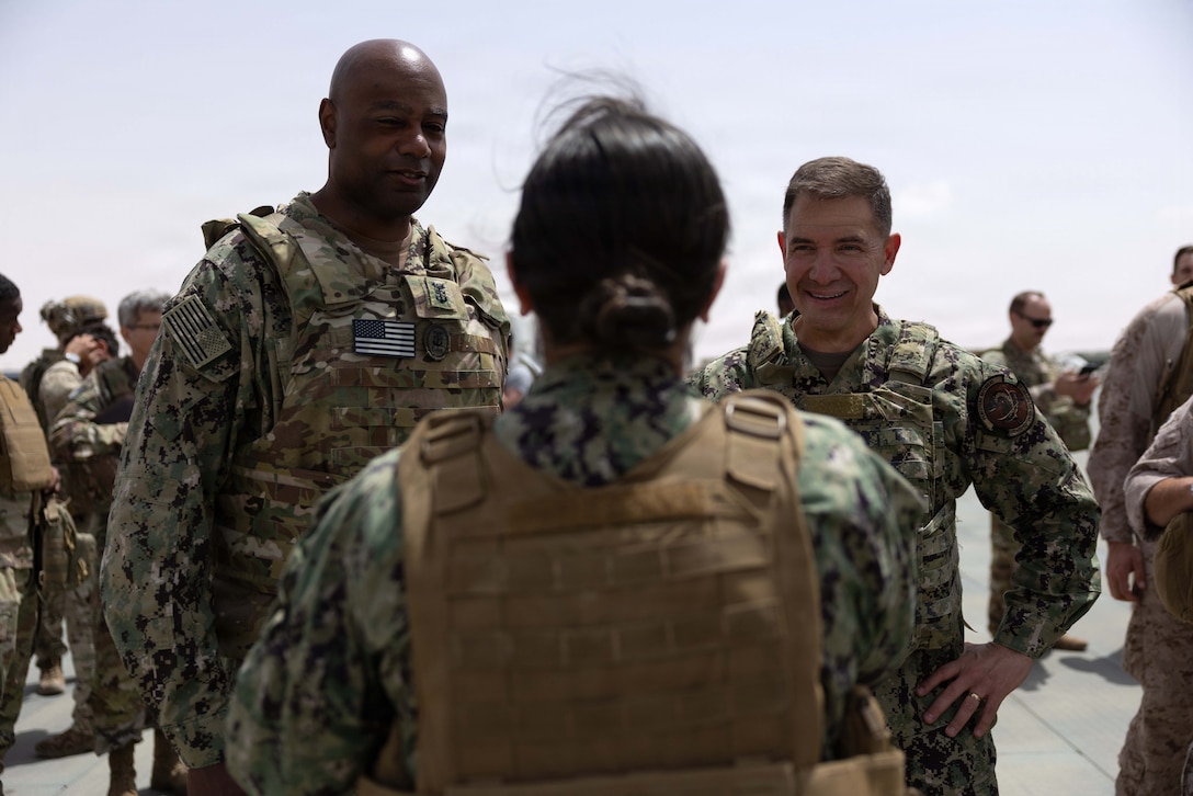 U.S. Navy Admiral Brad Cooper, commander of U.S. Central Command, and U.S. Navy Fleet Master Chief Lateef N. Compton, senior enlisted leader of U.S. Central Command, speak with a U.S. Navy Sailor during a troop engagement at a base in the Middle East. Cooper and Compton visited troops to answer questions and recognize their achievements in their continued efforts. (U.S. Navy photo by Senior Chief Mass Communication Specialist Amanda Dunford)