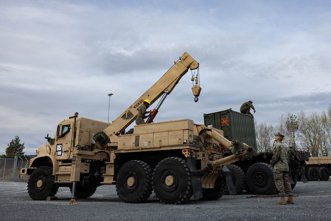 U.S. Marines with Combat Logistics Battalion 24, Combat Logistics Regiment 27, 2nd Marine Logistics Group, transfer equipment between vehicles in preparation for a long-range convoy during exercise Aurora as part of Sword 26 in Værnes, Norway, April 18, 2026. The Marines are preparing vehicles to ensure all equipment is mission-capable and safely configured for an upcoming movement across challenging Norwegian and Swedish terrain. U.S. Marines and Sailors with 2nd Marine Logistics Group are participating in Aurora as part of the larger Sword 26 series of linked multinational exercises. This participation directly supports NATO's Eastern Flank Deterrence Initiative concept, validates defense plans, builds a unified lethal force, and strengthens deterrence. (U.S. Marine Corps photo by Lance Cpl. Brady Hathaway)