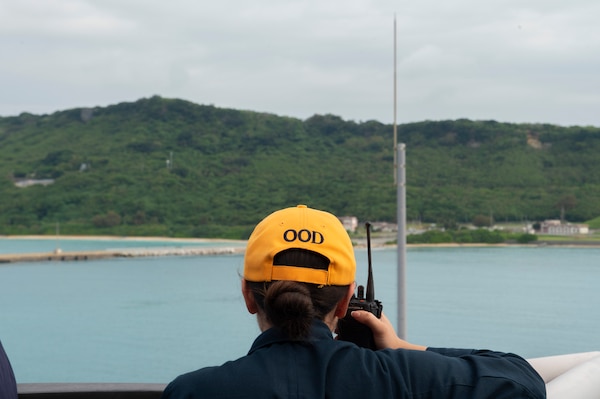 Ensign Zoe Alvarez communicates via radio on the bridge wing aboard U.S. 7th Fleet flagship USS Blue Ridge (LCC 19) as the ship prepares to enter port for a scheduled port visit at White Beach Naval Facility in Okinawa, Japan, April 19, 2026.