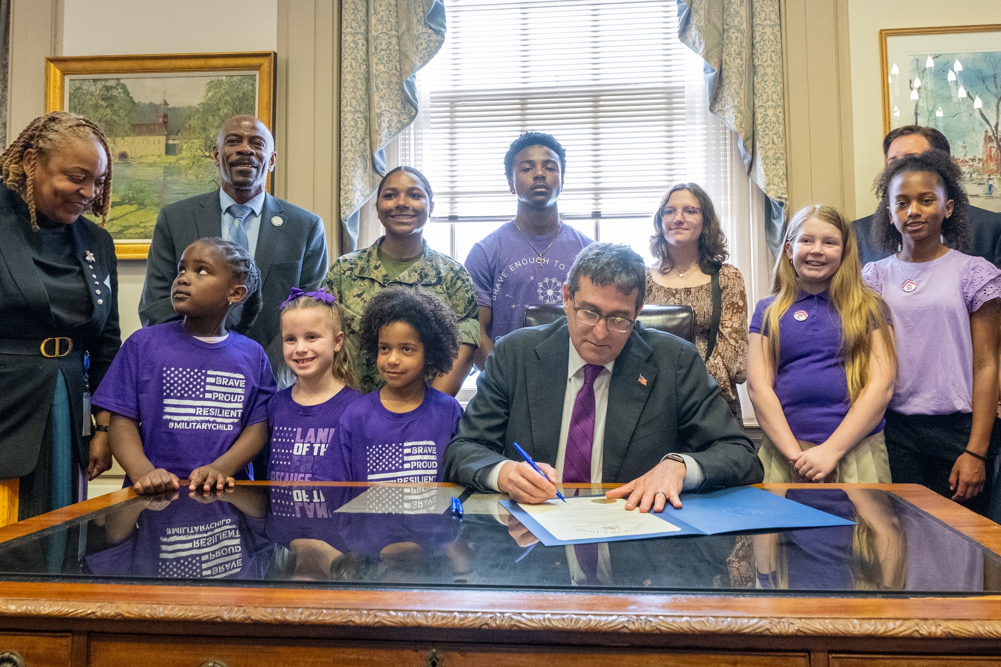 Delaware Gov. Matt Meyer signs a document proclaiming April as the Month of the Military Child surrounded by students, parents and faculty from various schools in Dover, Delaware, April 16, 2026. The Month of the Military Child was established in 1986 to recognize the contributions and personal sacrifices children make during their parents’ service in the armed forces.
(U.S. Air Force photo by Mauricio Campino)