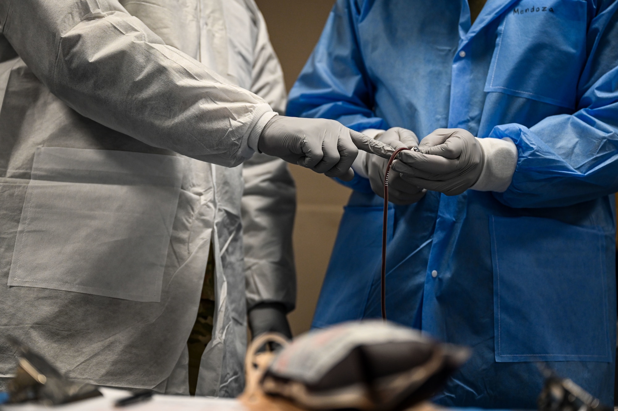 U.S. Army Staff Sgt. Malik Wright, Landstuhl Regional Medical Center Blood Donor Center medical laboratory specialist, left, shows Pfc. Jimmy Mendoza-Mendoza, 30th Medical Brigade laboratory specialist, right, how to strip blood into a bag to prevent clotting during a blood drive at Ramstein Air Base, Germany, April 20, 2026.