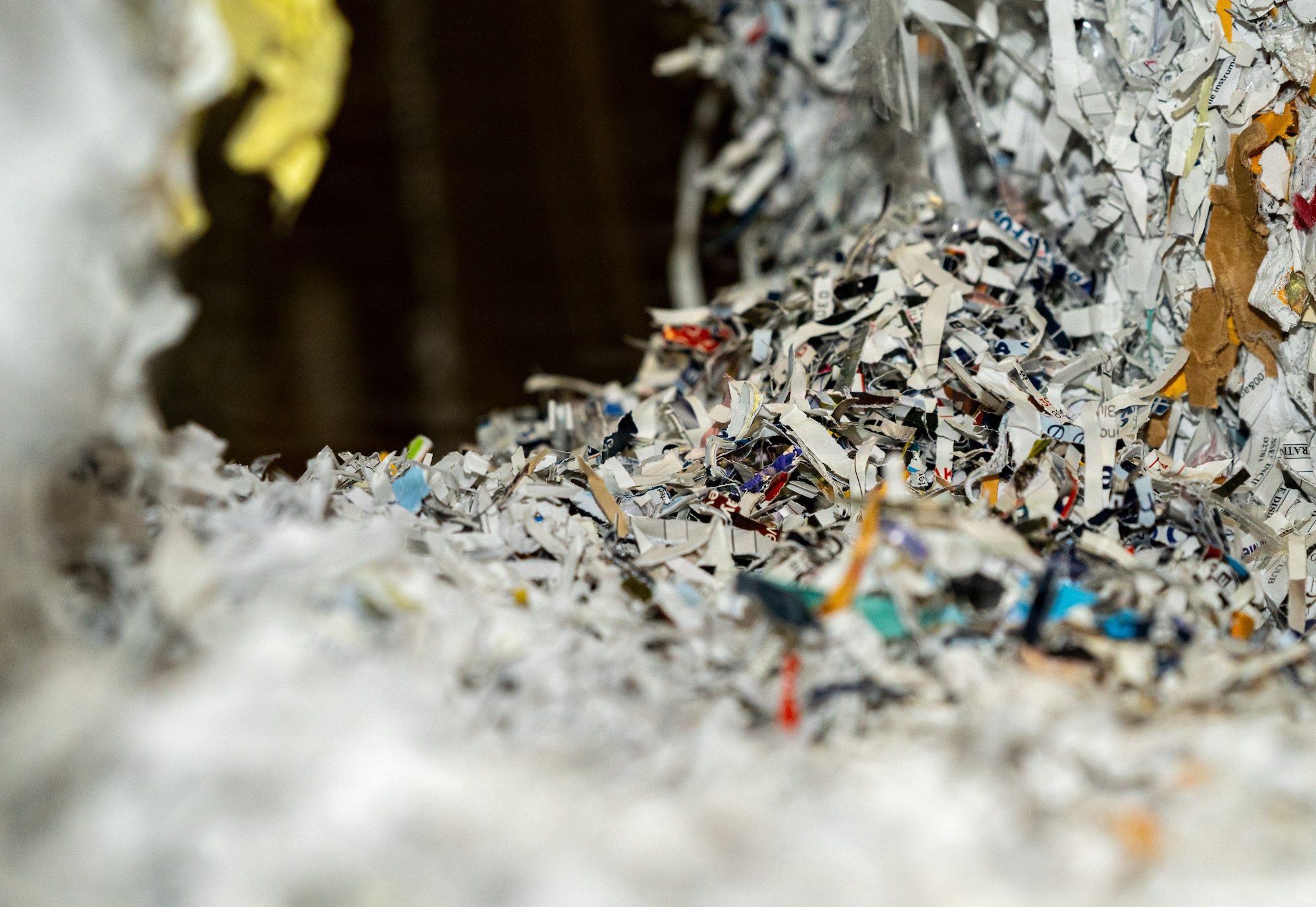 A loose pile of shredded paper in a warehouse with dim lighting.