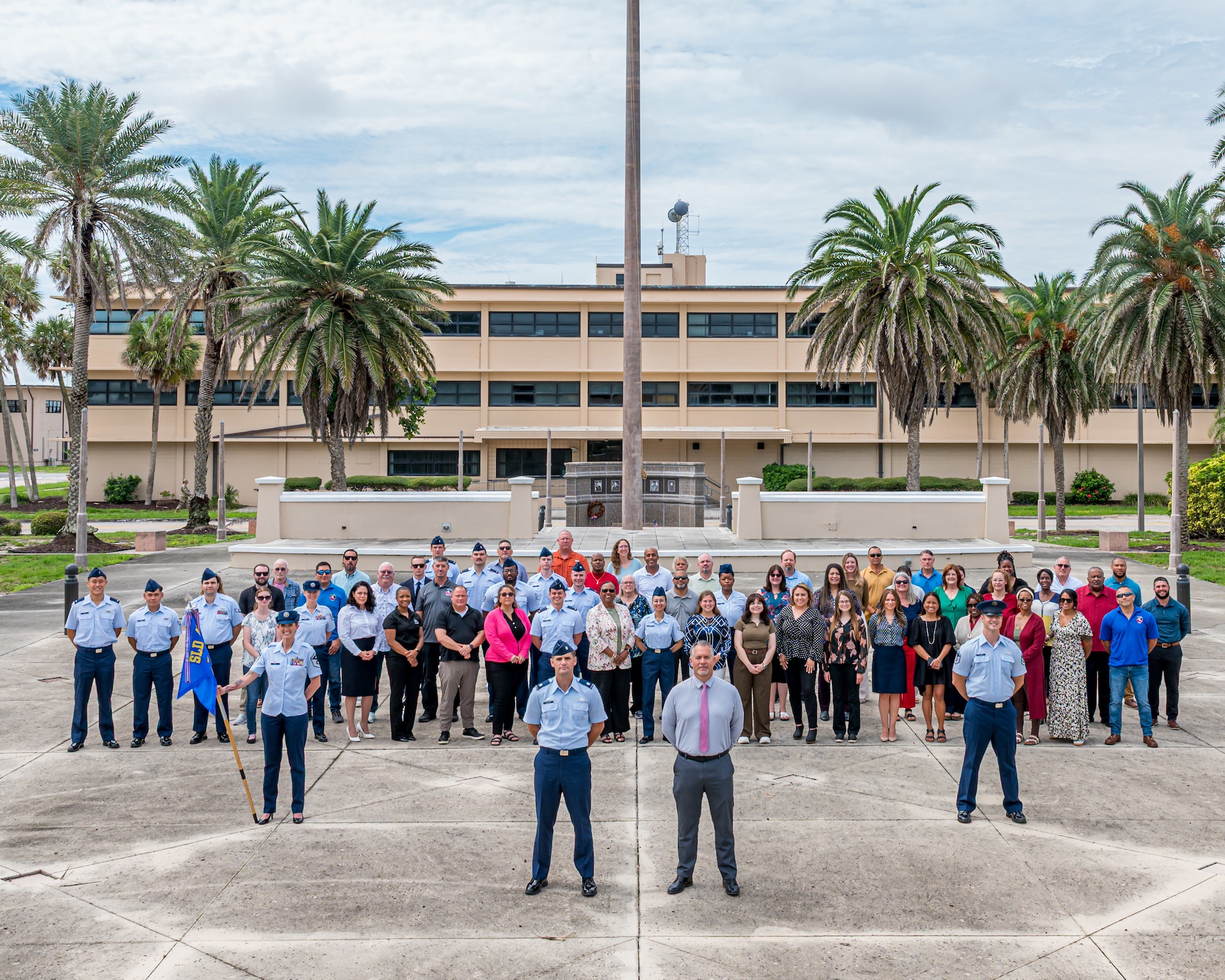 Members of the 45th Contracting Squadron pose for a group photo in front of the base flagpole at Patrick Space Force Base, Florida, Sept. 9, 2025. The team awards and manages contracts of outside companies that aid in supporting the Space Launch Delta 45 mission. (U.S. Space Force photo by Gwendolyn Kurzen).