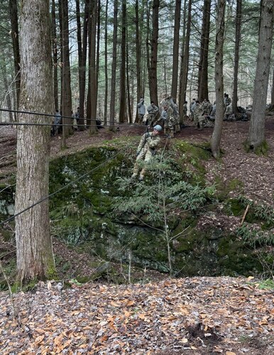 image of an Airman crossing a ravine using a high-line rope system.