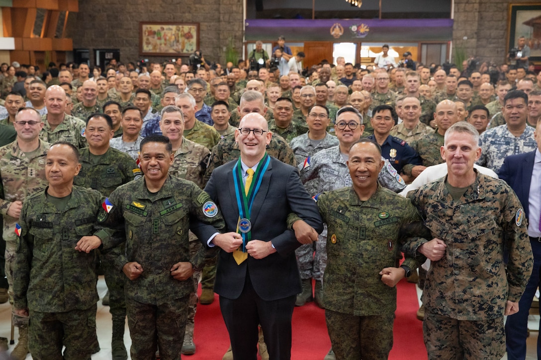 U.S. and Armed Forces of the Philippines service members alongside service members from Australia, Japan, Canada, France, and New Zealand joined in the locking of arms to signify the shoulder-to-shoulder nature of Exercise Balikatan 2026 during the opening ceremony at Camp General Emilio Aguinaldo, Manila, Philippines, April 20, 2026. Balikatan is a longstanding annual exercise between the AFP and U.S. military designed to strengthen our ironclad alliance, improve our capable combined force, and demonstrate our commitment to regional security and stability. (U.S. Army photo by Sgt. Brendon Donahue)