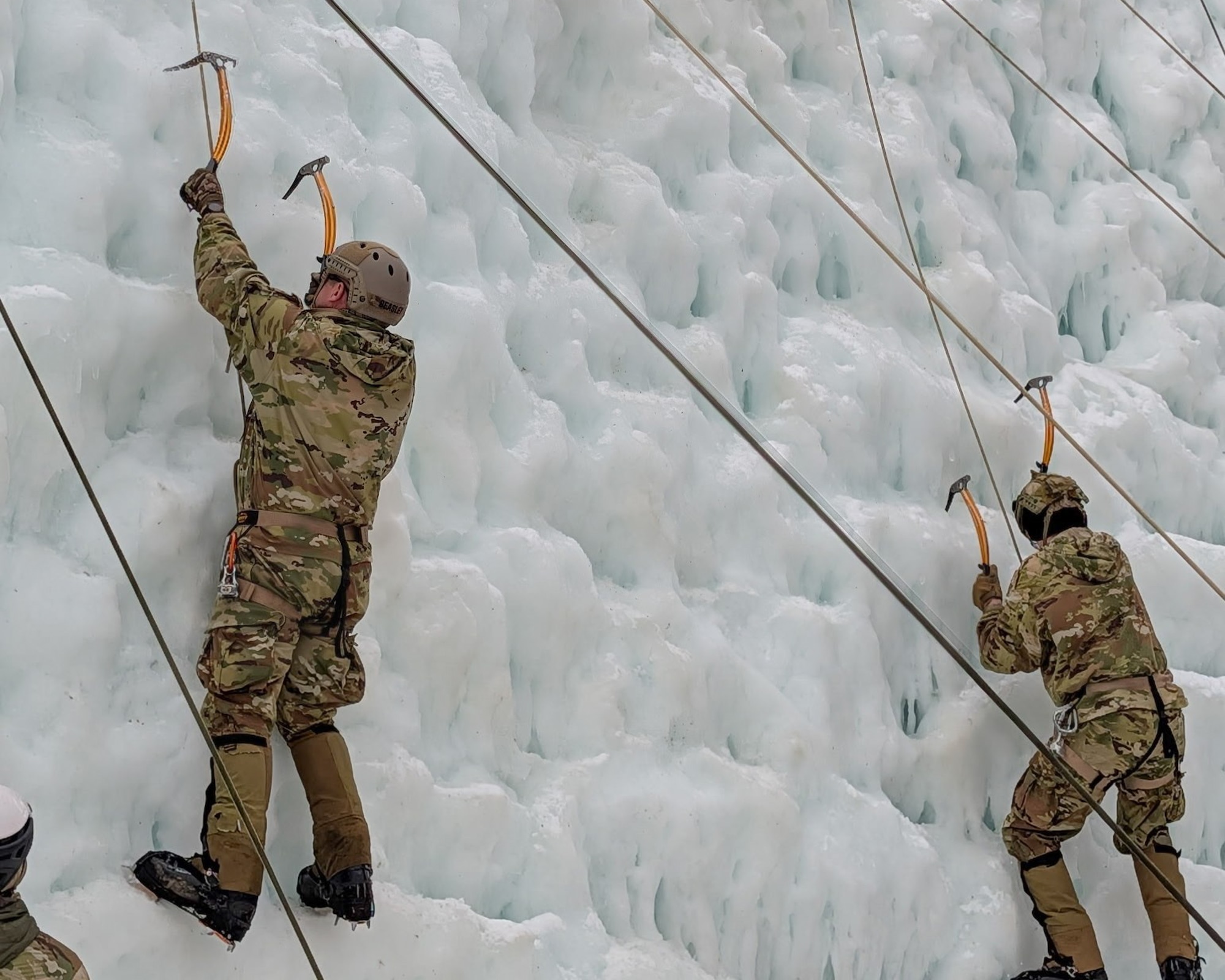 image of military personnel climbing up an ice wall.