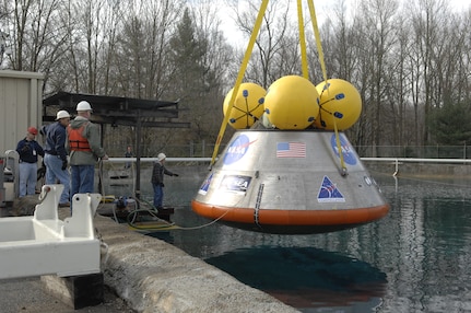 Engineers from Naval Surface Warfare Center, Carderock Division lower a full-scale Orion capsule test article into the Carderock test pond
