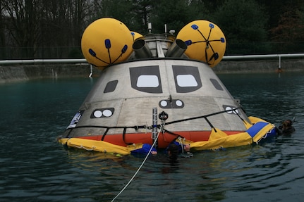 A full-scale Orion capsule test article is evaluated in the Carderock test pond during early recovery testing.