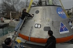 Engineer Lauren “Tink” Hanyok conducts final checks on the hatch mechanism of an Orion capsule test article at Naval Surface Warfare Center, Carderock Division’s test pond