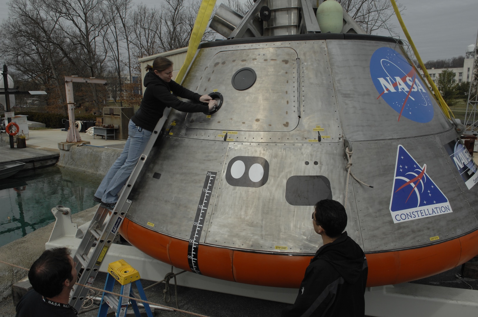 Engineer Lauren “Tink” Hanyok conducts final checks on the hatch mechanism of an Orion capsule test article at Naval Surface Warfare Center, Carderock Division’s test pond