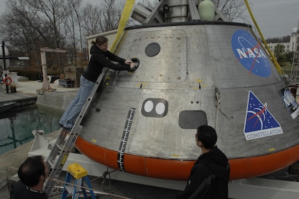 Engineer Lauren “Tink” Hanyok conducts final checks on the hatch mechanism of an Orion capsule test article at Naval Surface Warfare Center, Carderock Division’s test pond