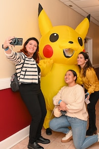 Four people pose for a photo, one of them in costume.