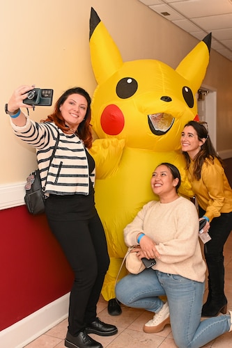 Four people pose for a photo, one of them in costume.