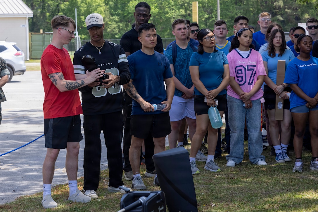 U.S. Marines with the Marine Corps Installations East (MCIEAST) Regional Personnel Administration Center (RPAC), pass around the 2025 Personnel Administration Center of the Year Award after an award ceremony at Marine Corps Base Camp Lejeune, North Carolina, April 16, 2026. MCIEAST RPAC won this award for its efficient and accurate administrative, pay, and reporting support across multiple installations, ensuring that Marines' records were properly maintained and they remained ready for worldwide deployment. (U.S. Marine Corps photo by Cpl. Jessica J. Mazzamuto)