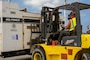 a forklift operator uses a forklift to move a large generator.