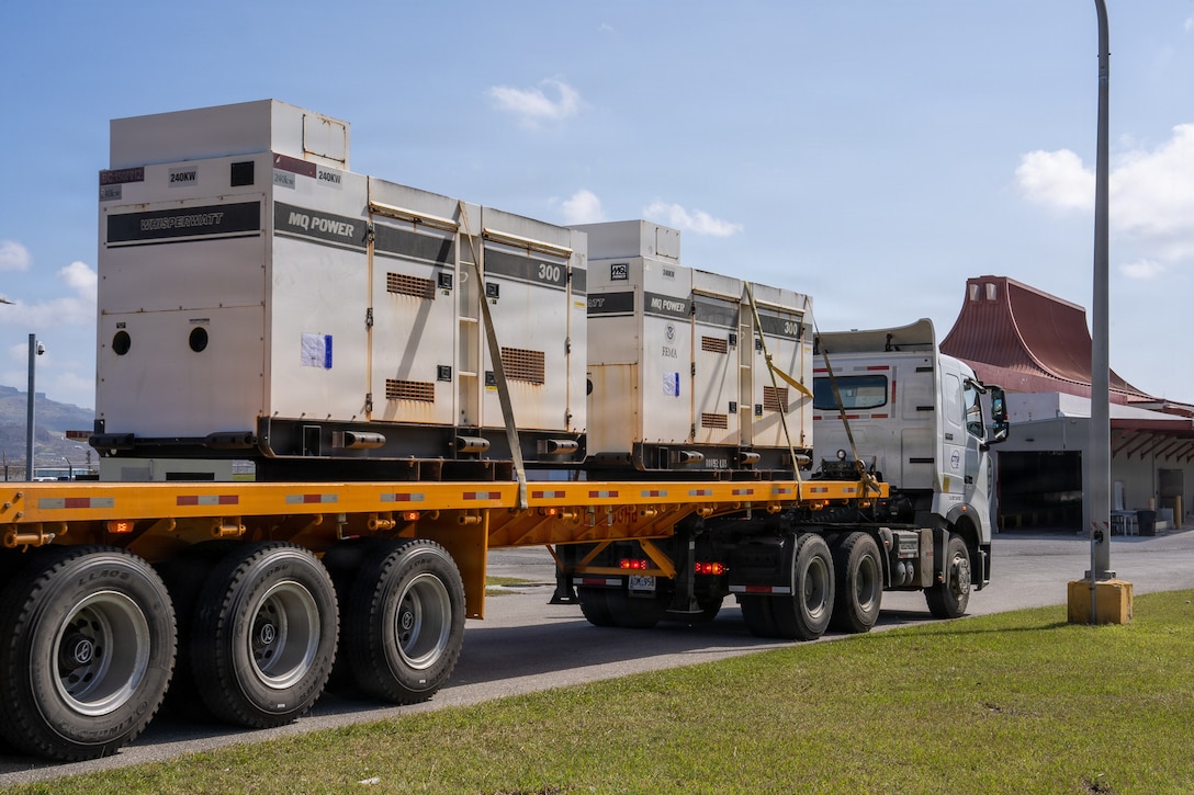a flatbed truck is loaded with two large generators
