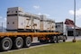a flatbed truck is loaded with two large generators