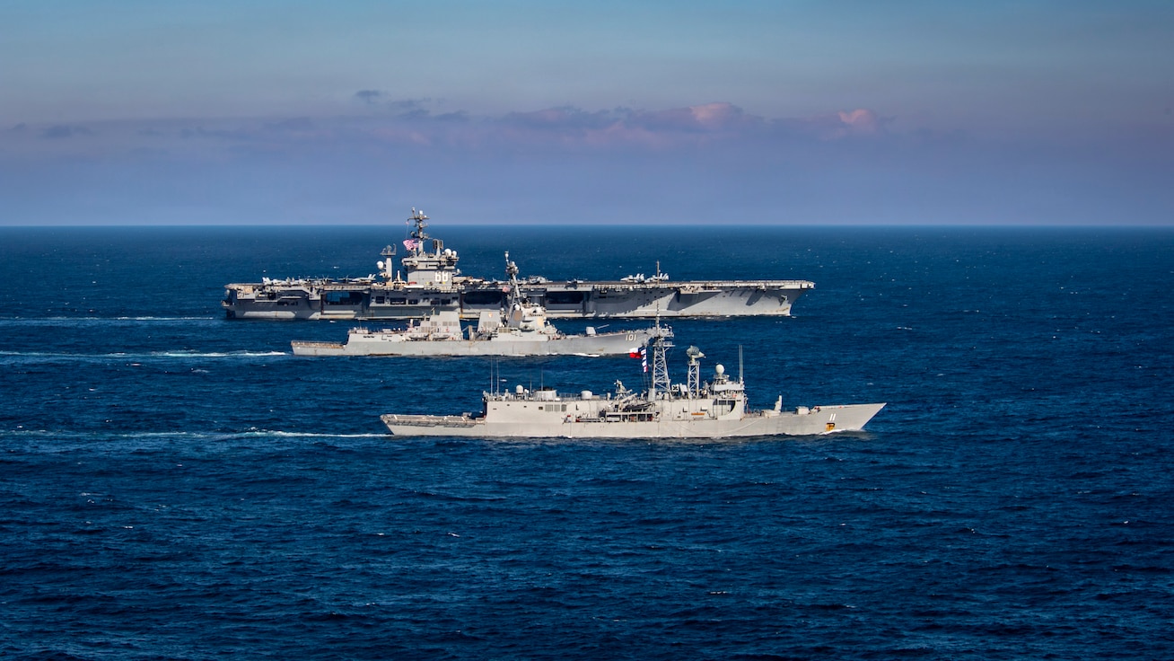 Three warships sail in formation together.