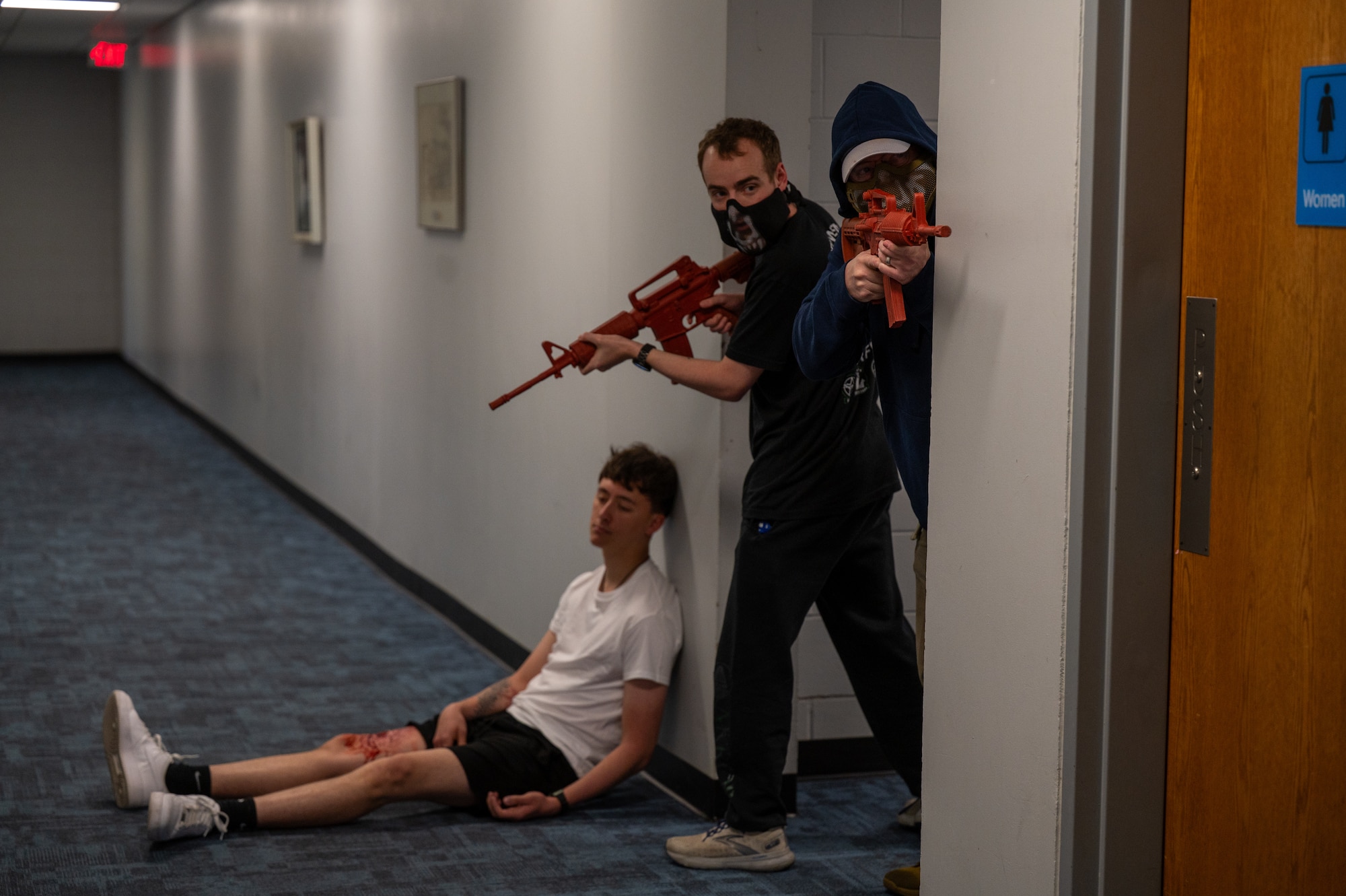 U.S. Air Force Airman 1st Class Keith Houtz, left, Air Force Wargame Institute wargaming IT technician, Airman 1st Class Tyler Wamsley, middle, 42d Air Base Wing Judge Advocate general law paralegal, and Capt. John Shortell, left, Air Force Wargame Institute red team analyst, participate in an active shooter simulation at Maxwell Air Force Base, Alabama, April 15, 2026. Personnel responded to a simulated active shooter scenario during MAXFORCE 26-02 to assess response procedures and interagency coordination. (U.S. Air Force photo by Staff Sgt. Evan Porter)