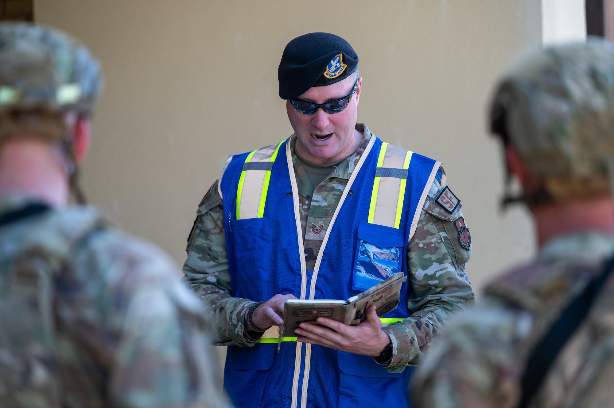 U.S. Air Force Tech. Sgt. Gregory Twigg, 42d Security Forces Squadron noncommissioned officer in charge of standardization and evaluation, reads his notes to security forces personnel at Maxwell Air Force Base, Alabama, April 15, 2026. Twigg evaluated the personnel during a simulated active shooter scenario. (U.S. Air Force photo by Staff Sgt. Evan Porter)