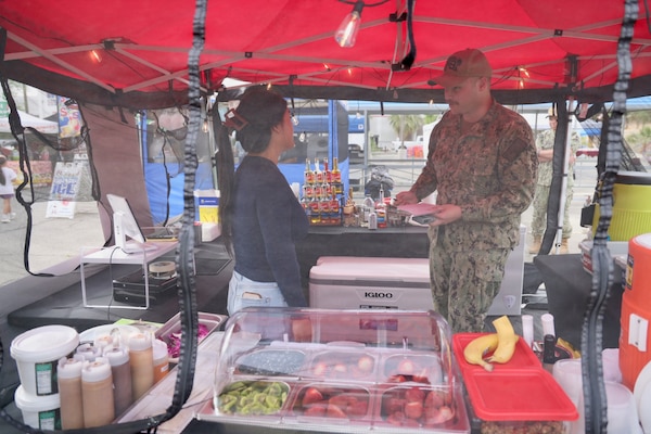 Hospitalman Apprentice Wilson Current (right) inspects a new vendor at the 29 Palms Farmers Market at Marine Corps Air Ground Combat Center (MCAGCC), April 9, 2026. Preventive medicine technicians ensure vendors comply with Navy and Department of War food safety standards, supporting the health and readiness of service members and their families. (U.S. Navy photo by Christopher Jones, NMRTC/NH Twentynine Palms public affairs officer)