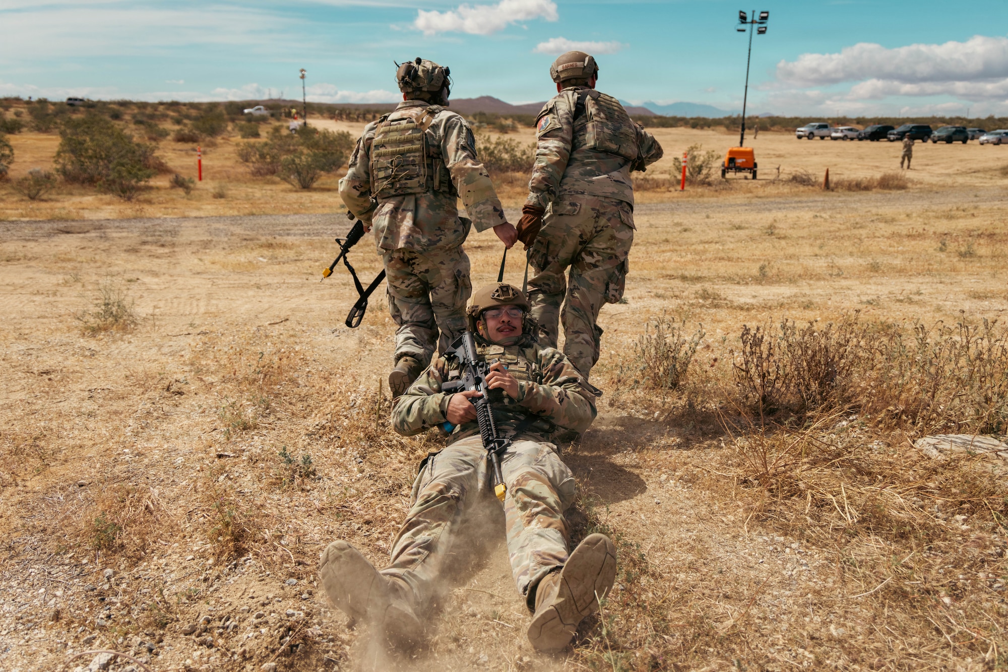 The 61st Security Forces Squadron's Air Force Tech. Sgt. Jesus Contreras and 1st Lt. Jared Barnes, pull Senior Airman Alex Davila to safety during the annual Advanced Combat Training Exercise Close Quarters Battle Course at Edwards Air Force Base, California, April 2, 2026. (Air Force photo by Brandon Hernandez)