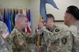 Col. Andrew Walsh passes the 304th Cyber Battalion's colors to Lt. Col. Joel Joyce during the battalion's Change of Command Ceremony at Camp Parks, Calif., on April 11, 2026.
