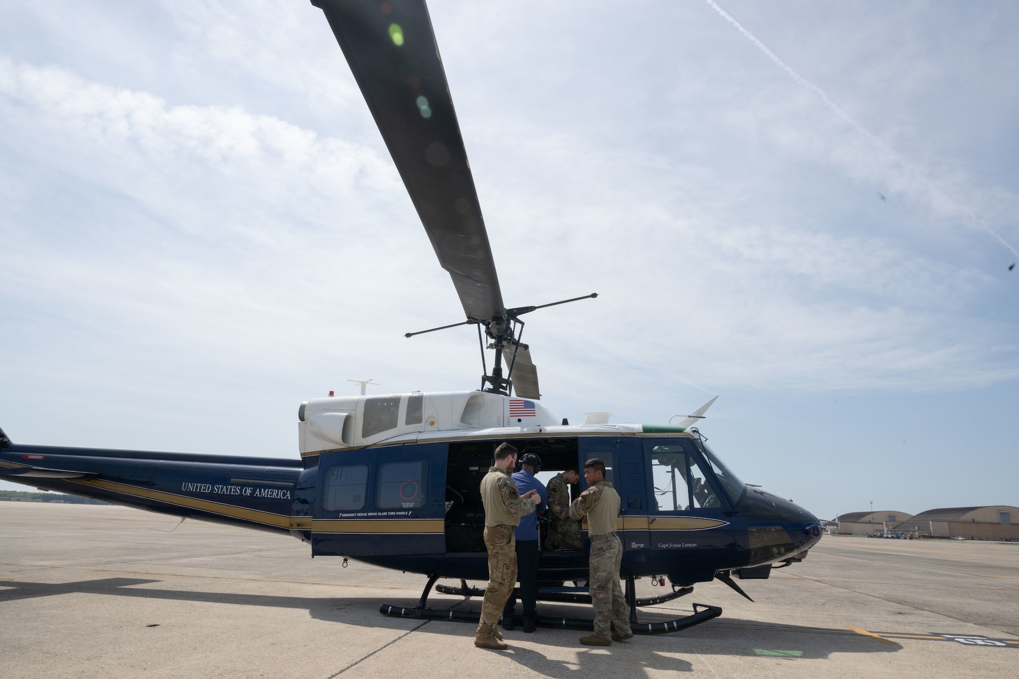 2 pilots standing next to a helicopter.