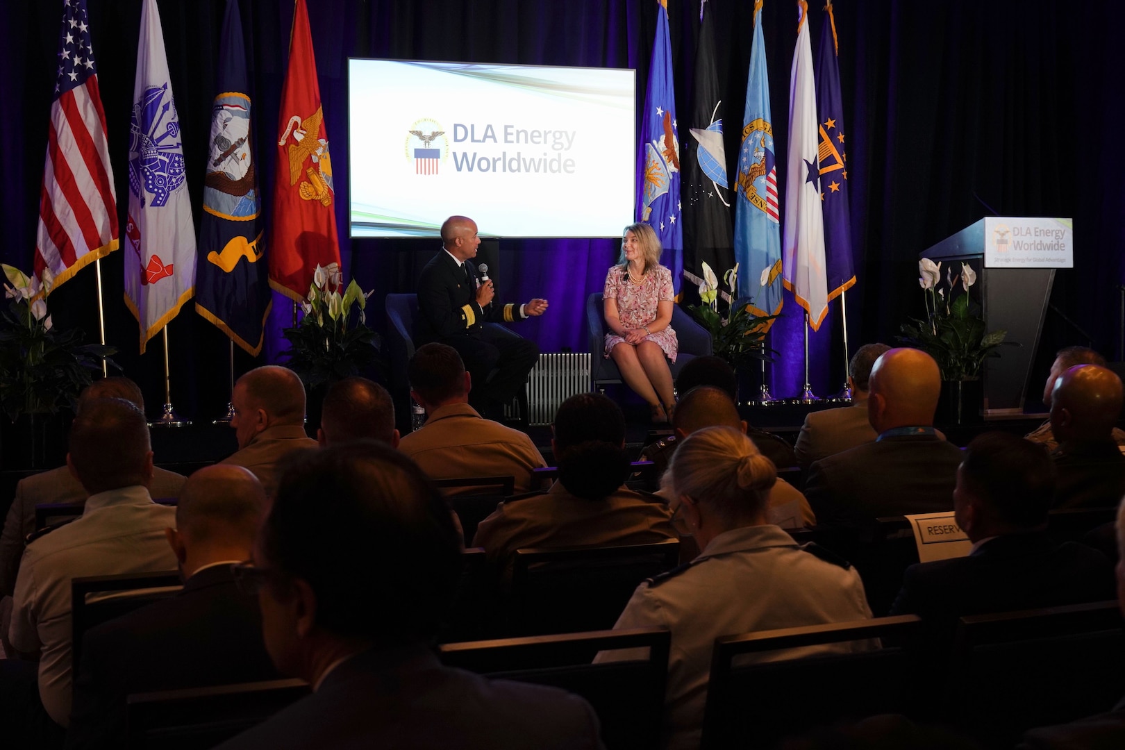 Two people talk on stage.