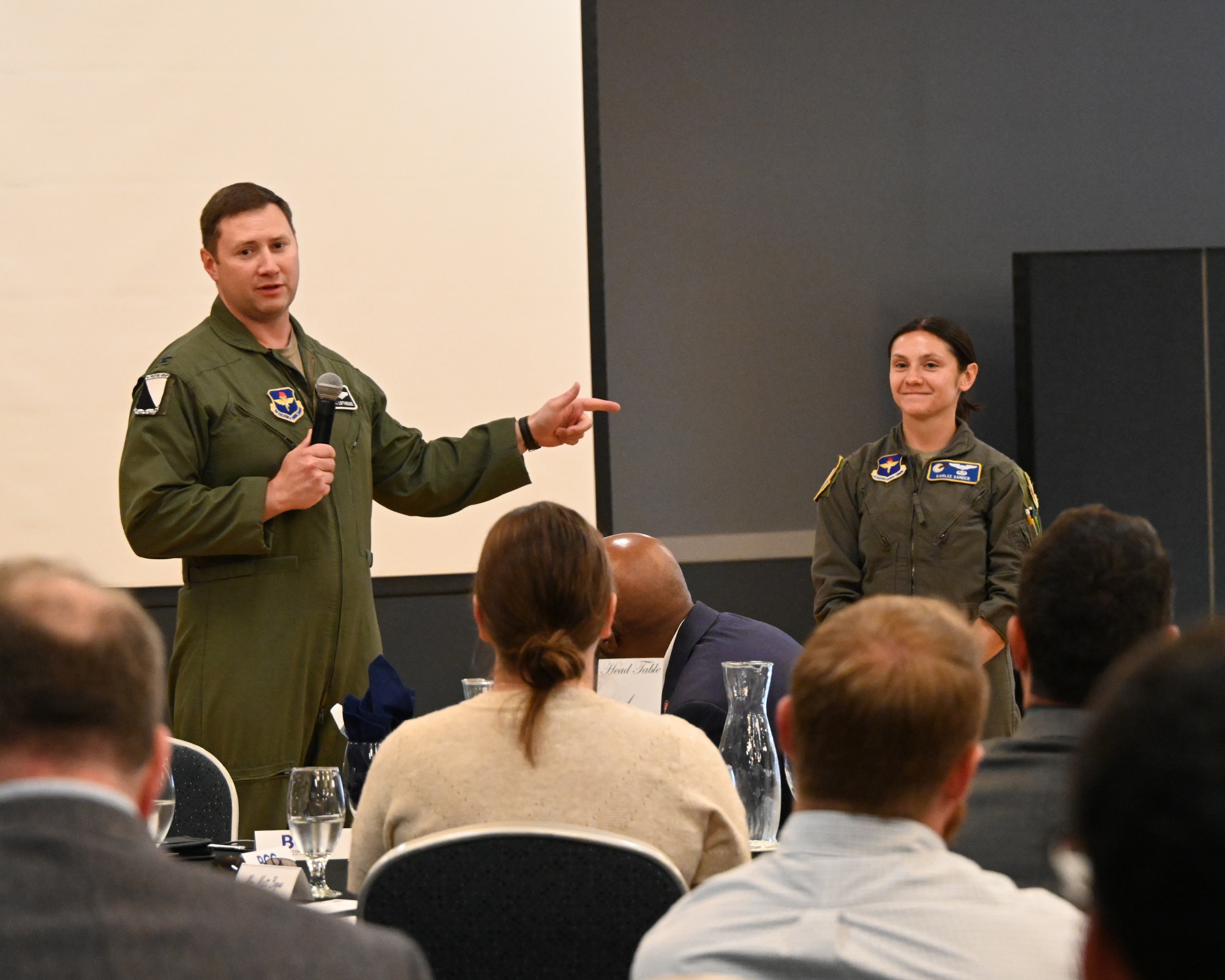 A commander points in the direction of a pilot during a BCC luncheon.