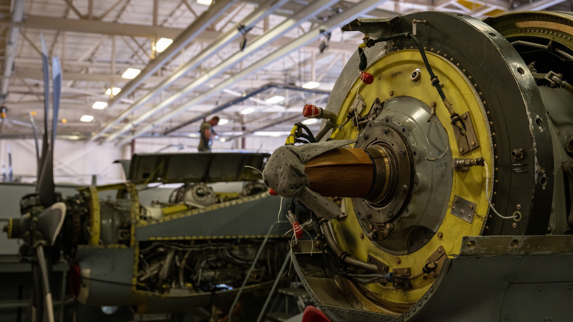 Airmen walk on top of a C-130H Hercules aircraft in safety harnesses performing an inspection of the aircraft.