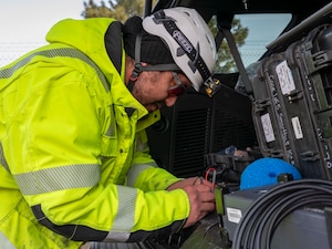 Contractors insert a device into a pipe.