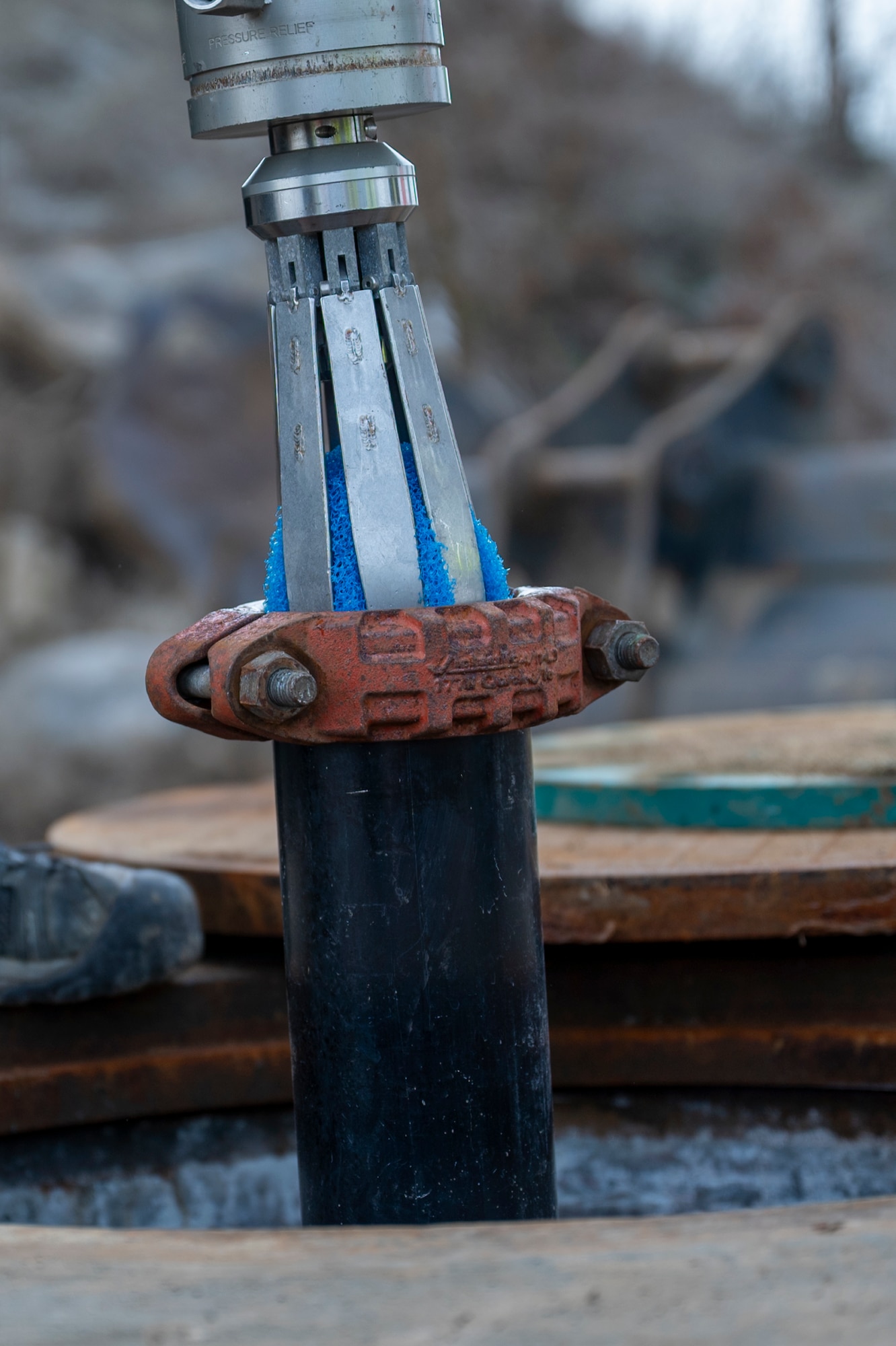 Contractors insert a device into a pipe.