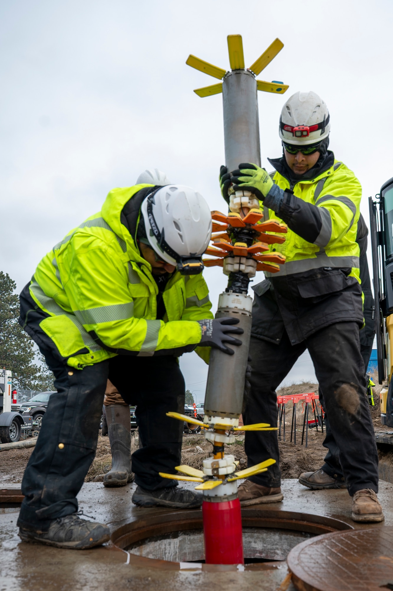 Contractors insert a device into a pipe.