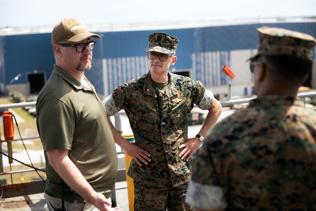Andrew Macleod, a contracted mariner and captain of the USNS Red Cloud, speaks with U.S. Marine Corps Col. David Merles, commanding officer of Blount Island Command, while U.S. Navy Rear Adm. Guido Valdes, the Medical Officer of the Marine Corps, listens during a tour April 22, 2026, at Marine Corps Support Facility Blount Island, Florida. The Marine Corps’ senior medical advisor and health services director visited Blount Island Command to gain ground-level insight into prepositioned medical capabilities supporting global operations. (Marine Corps photo by Dustin Senger)