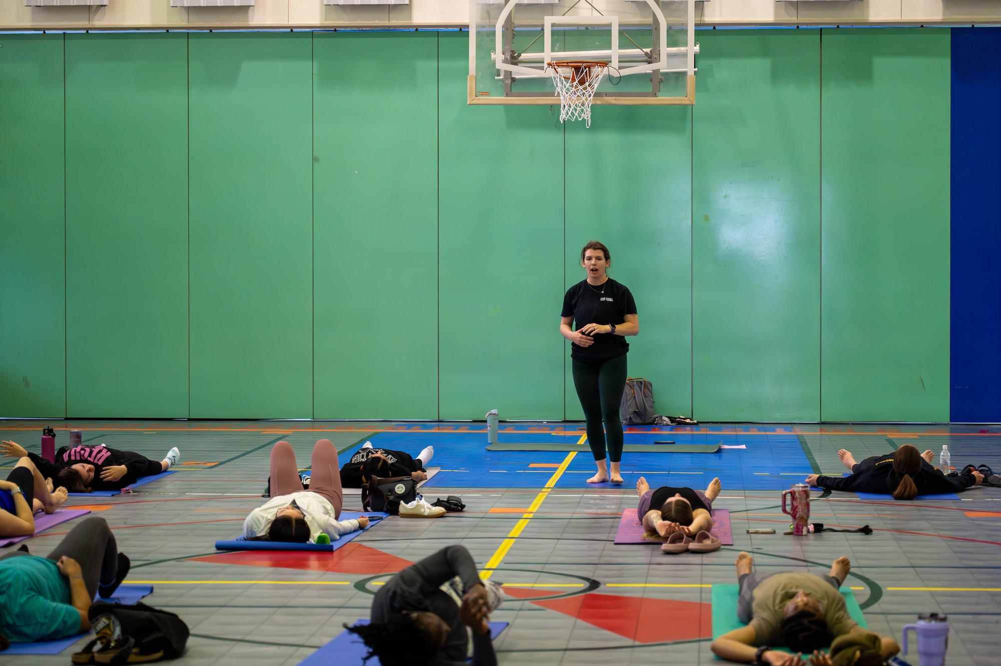 Service members and civilians do yoga.