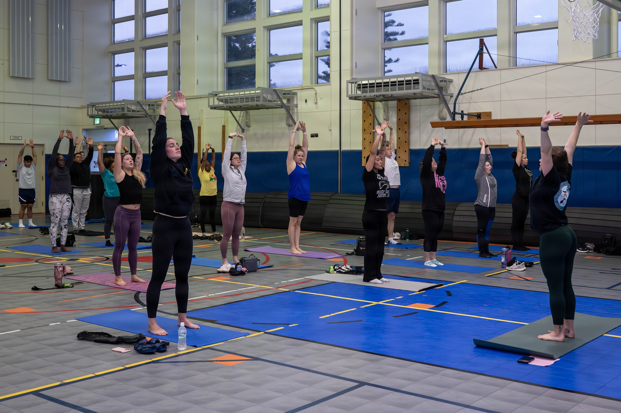 Service members and civilians do yoga.