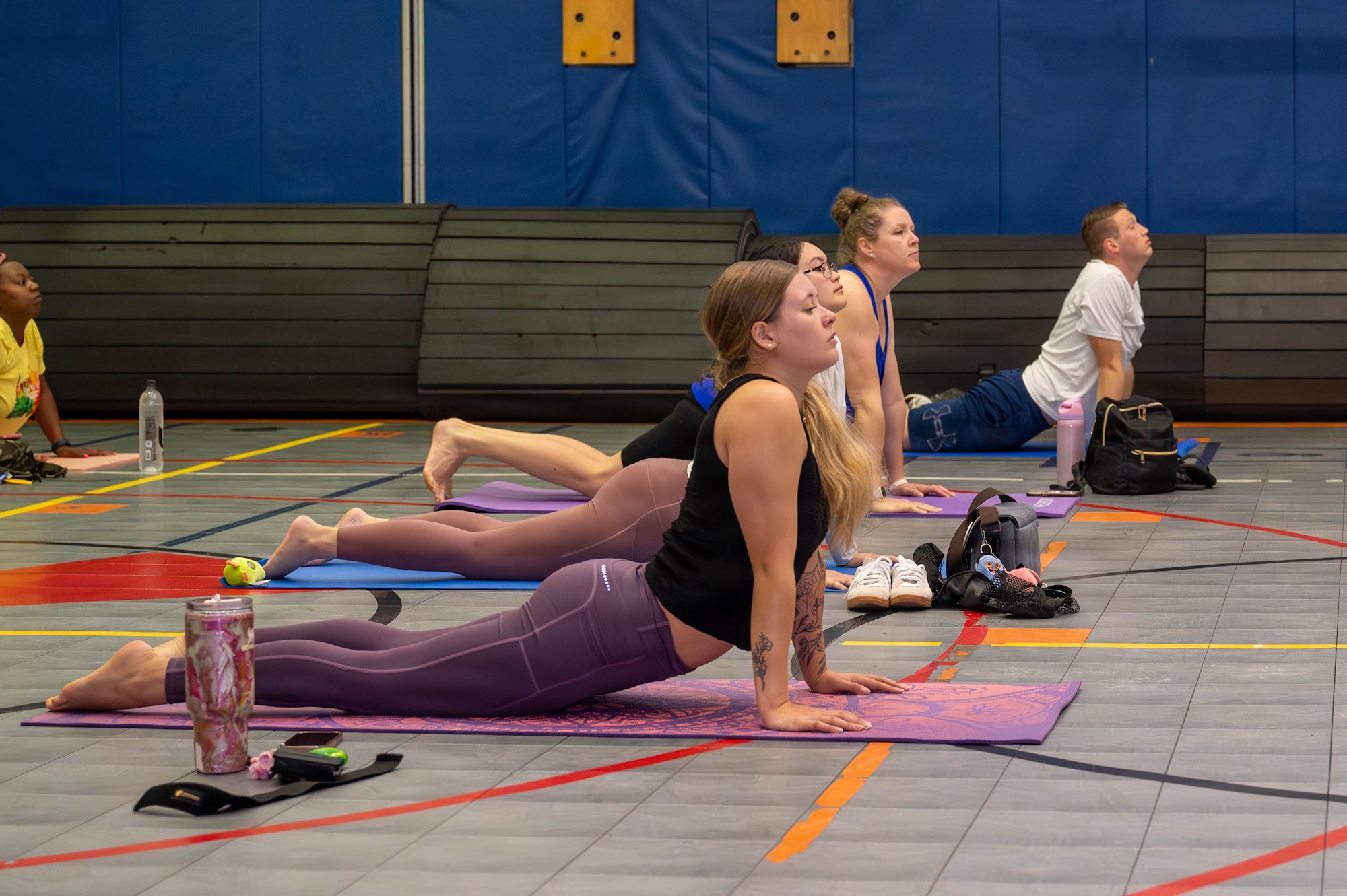 Service members and civilians do yoga.