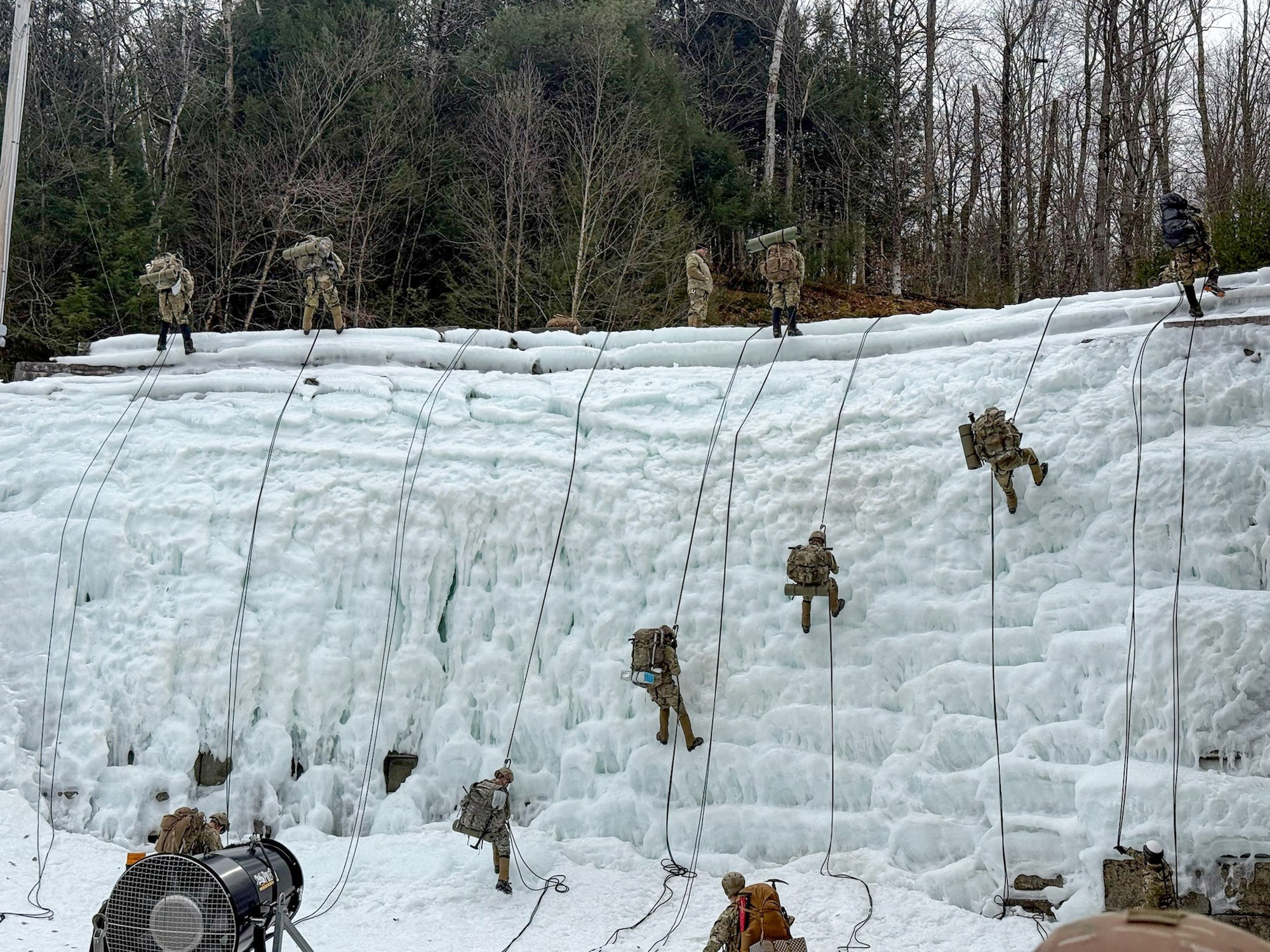 image of military personnel rappelling down an ice wall.