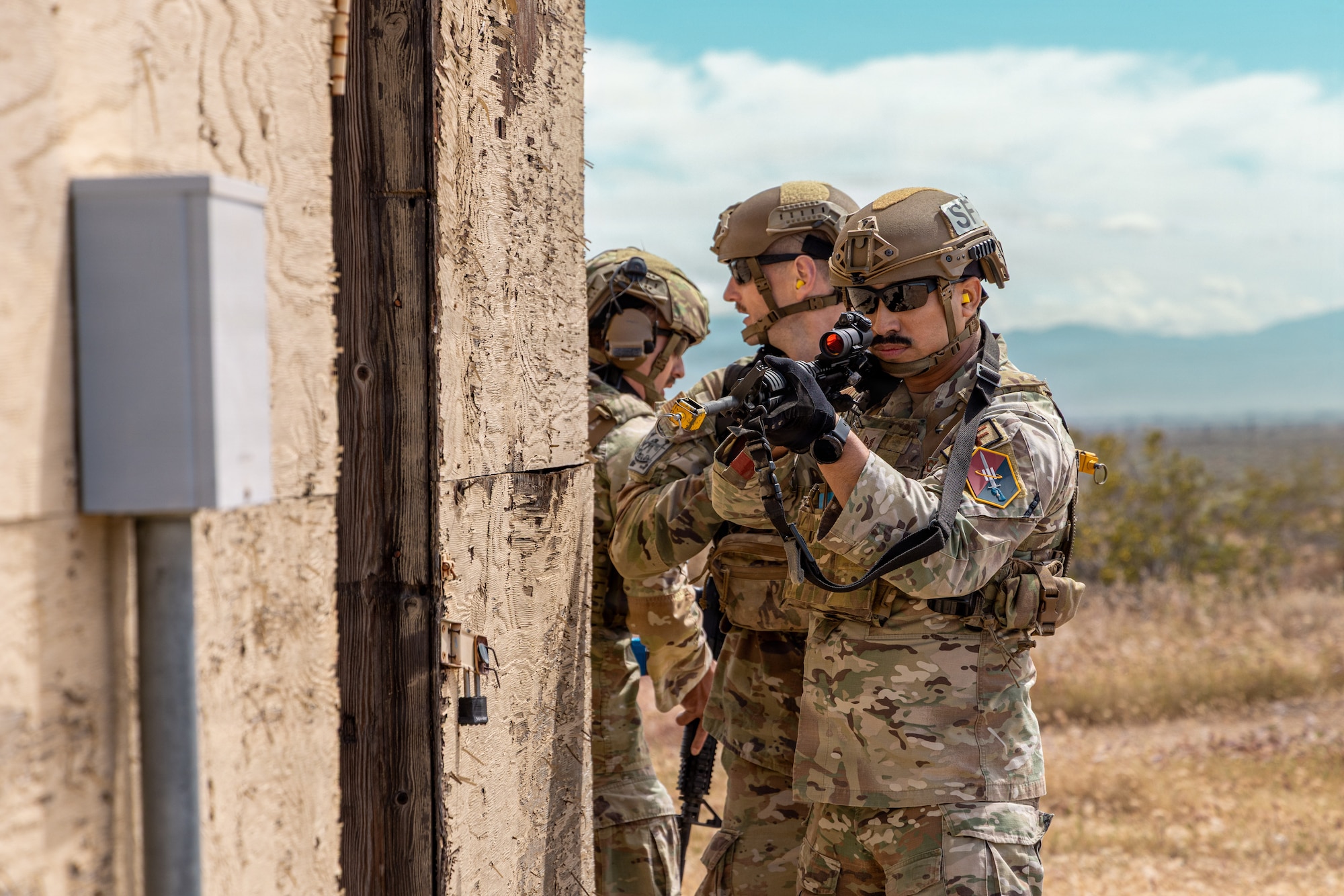 Air Force Tech. Sgt. Jesus Contreras, 1st Lt. Jared Barnes and Senior Airman Noah Bugiada of the 61st Security Forces Squadron move to secure a building during the annual Advanced Combat Training Exercise Close Quarters Battle Course at Edwards Air Force Base, California, April 2, 2026. (Air Force photo by Ariana Ortega)