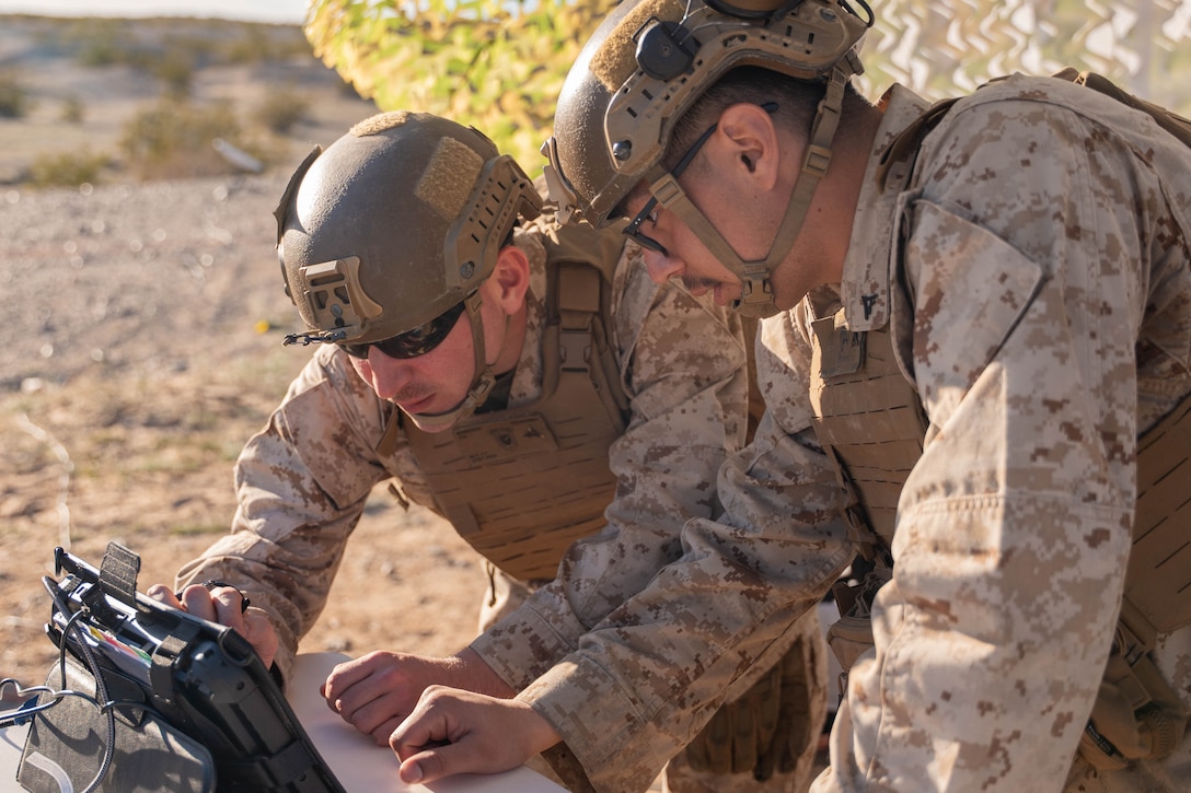 Marines looing a tablet that controls a drone