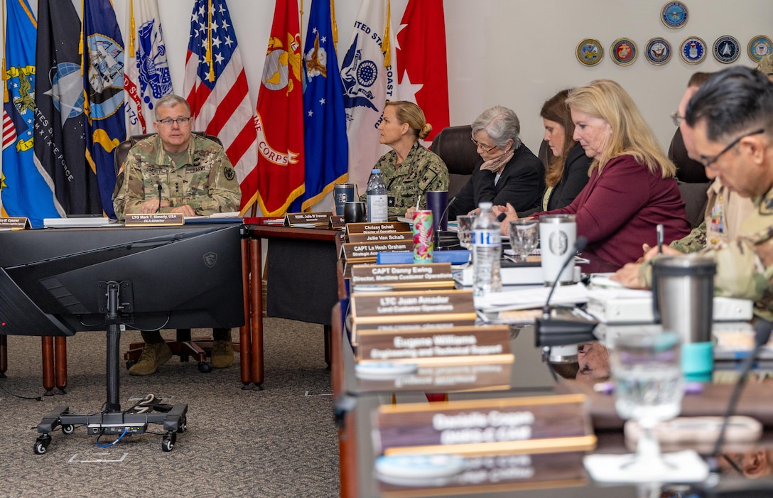 A group of people sit around a conference room table
