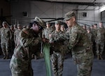 U.S. Army Capt. Jamee Finley, left, and 1st Sgt. Paul Jones, right, the company command team for the 150th Maintenance Company, case the colors at the Washoe County Armory in Stead, Nevada, April 18, 2026. The 150th Maintenance Company is deploying to the U.S. Central Command area of responsibility in support of Operation Inherent Resolve. Photo by Spc. Ahylin Arroyo.